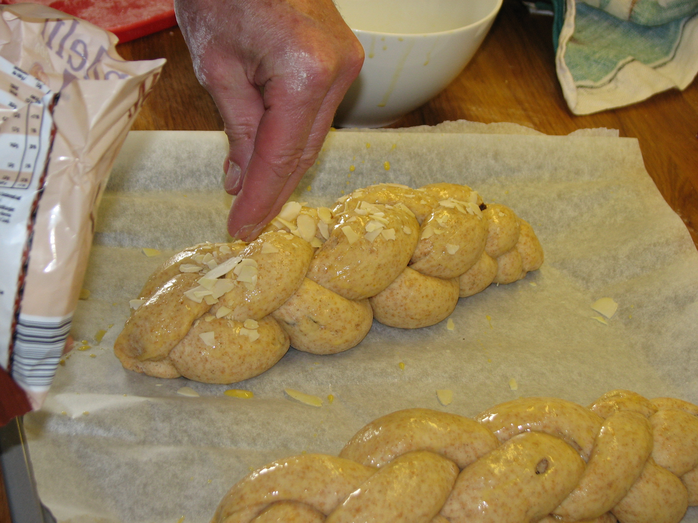 <p>Der mit verquirltem Eigelb bestrichene <a data-entity-substitution="canonical" data-entity-type="node" data-entity-uuid="de1b8548-ad42-458f-8d52-05d55a54bec9" href="/node/11917">Zweistrangzopf </a>wird mit Mandelblättchen bestreut.</p>