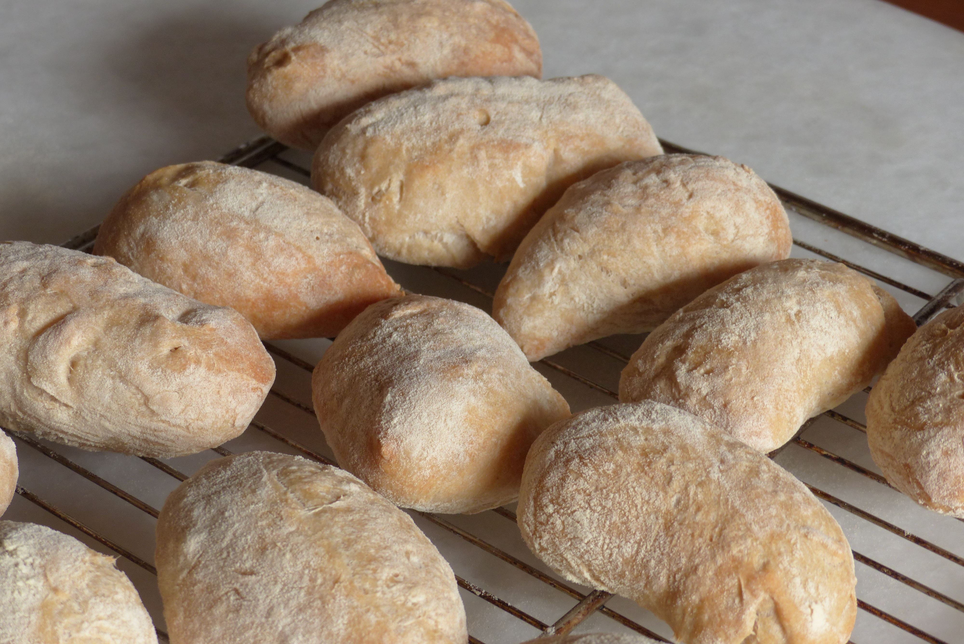 <p>Das - oftmals erwünschte - Mehl auf der Kruste der Ciabattini zeigt, dass sie vor dem Backen nur ganz leicht mit warmem Wasser besprüht wurden.</p>