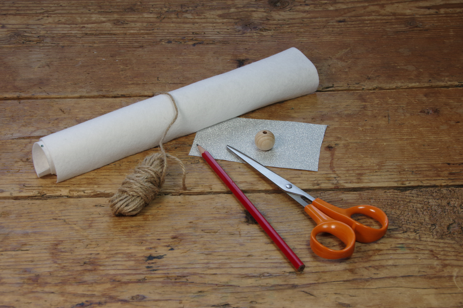 <p>Benötigt werden Weißer Filz, eine Holzkugel, Spagat, Glitzerpapier, Stift, Schere und Kleber sowieso.</p>