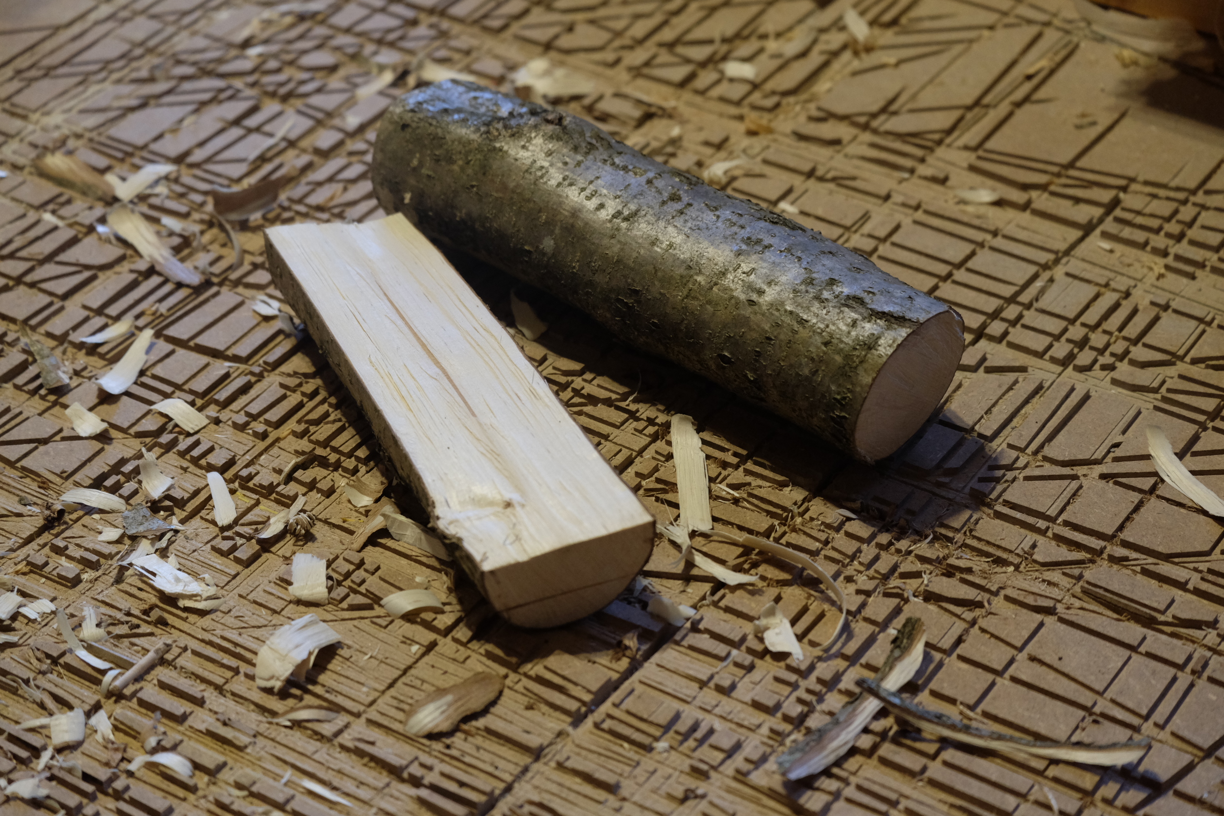 <p>Geeignet dicke Äste werden der Länge nach halbiert - entweder gespalten oder gesägt. Darauf wird die Form mit Bleistift vorgezeichnet.</p>