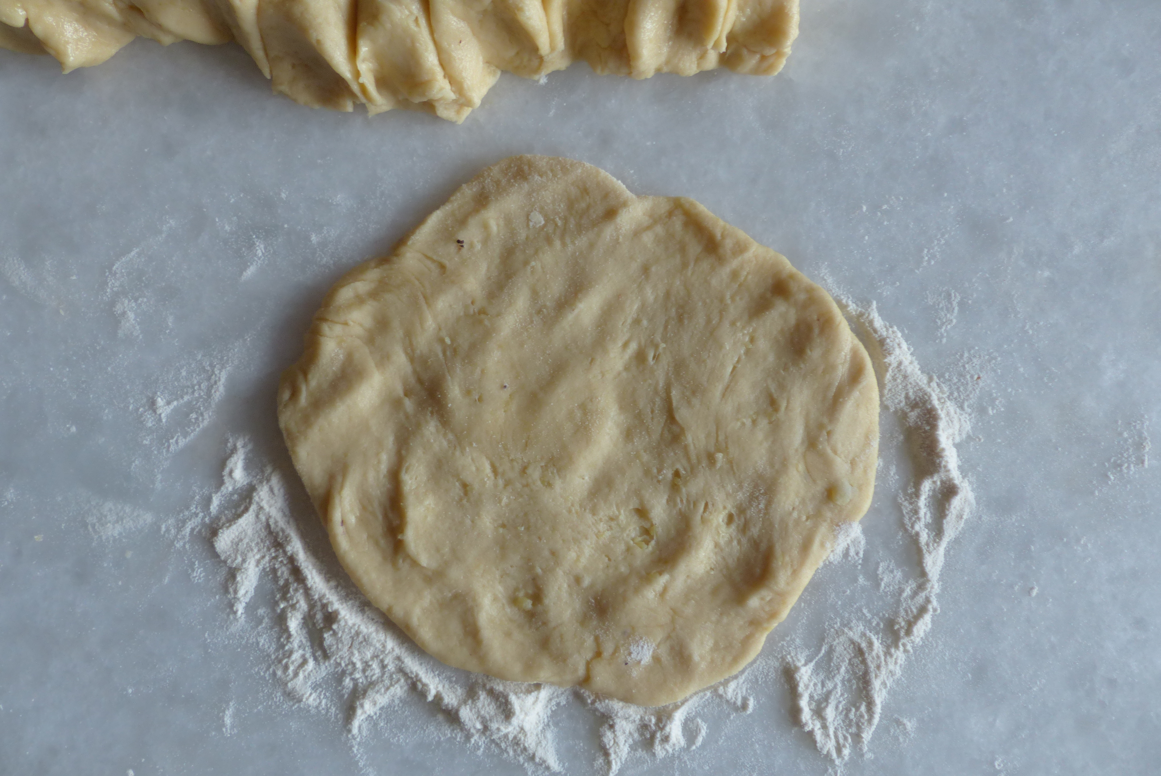 <p>Das Teigstück wurde mit den Fingern zu einem Fladen geformt.</p>