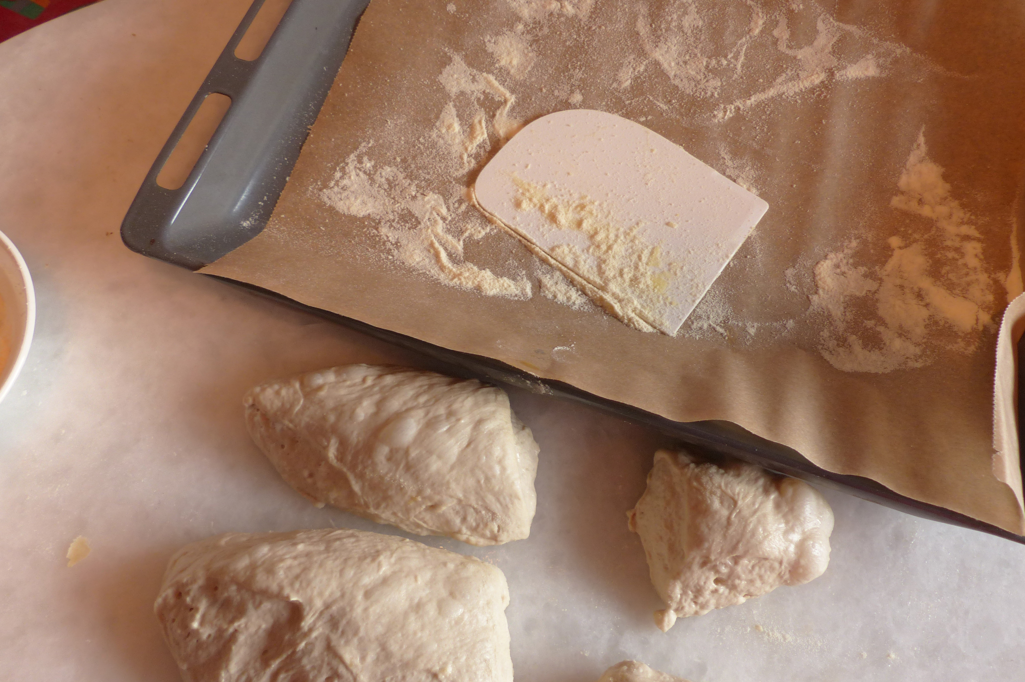 <p>Die mit der Teigkarte geschnittenen Teiglinge werden auf das mit Backpapier und Hartweizenmehl vorbereitete Backblech befördert.</p>