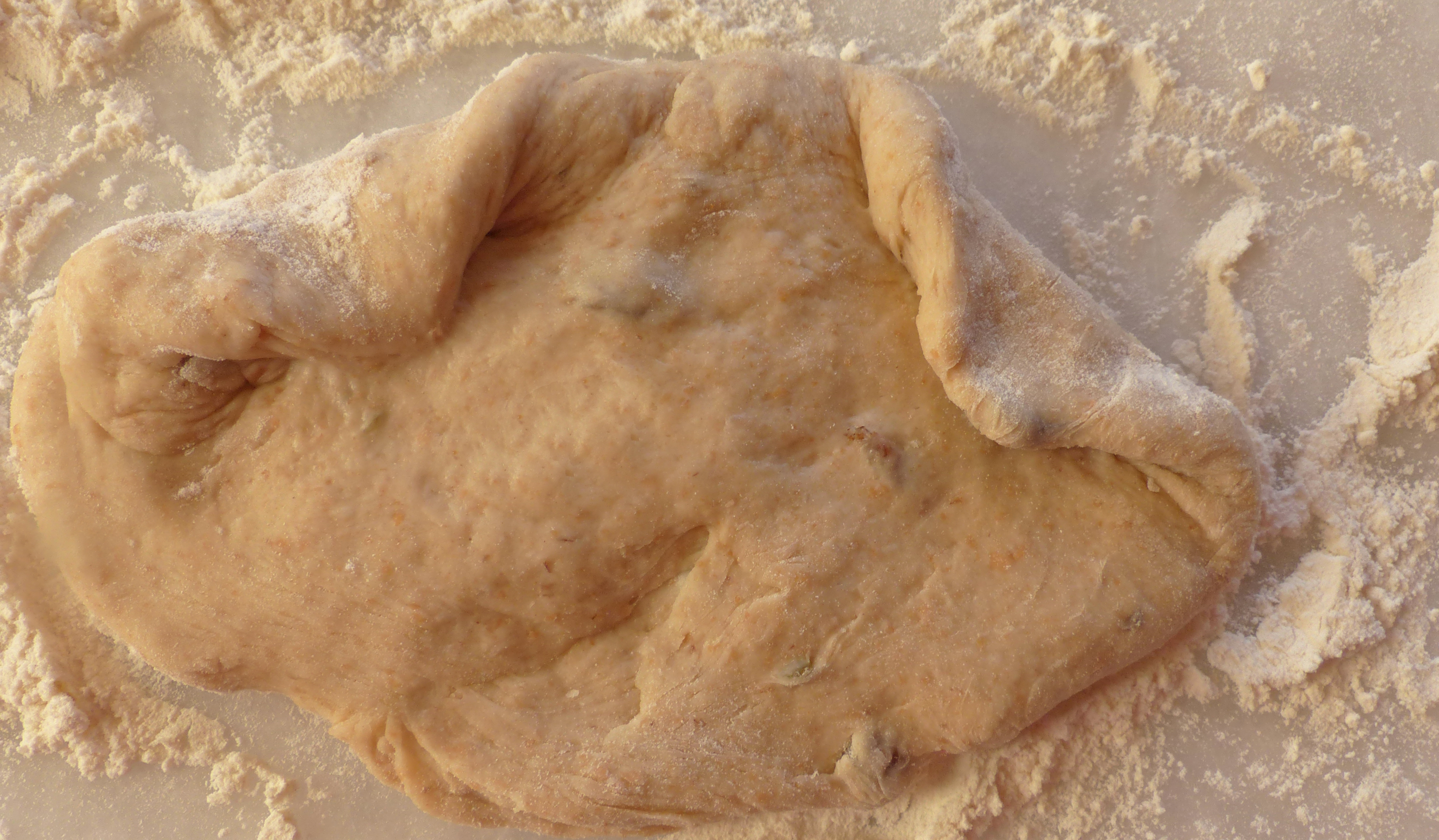 <p>Die oberen Fladenecken wie Schweinchenohren einklappen.</p>