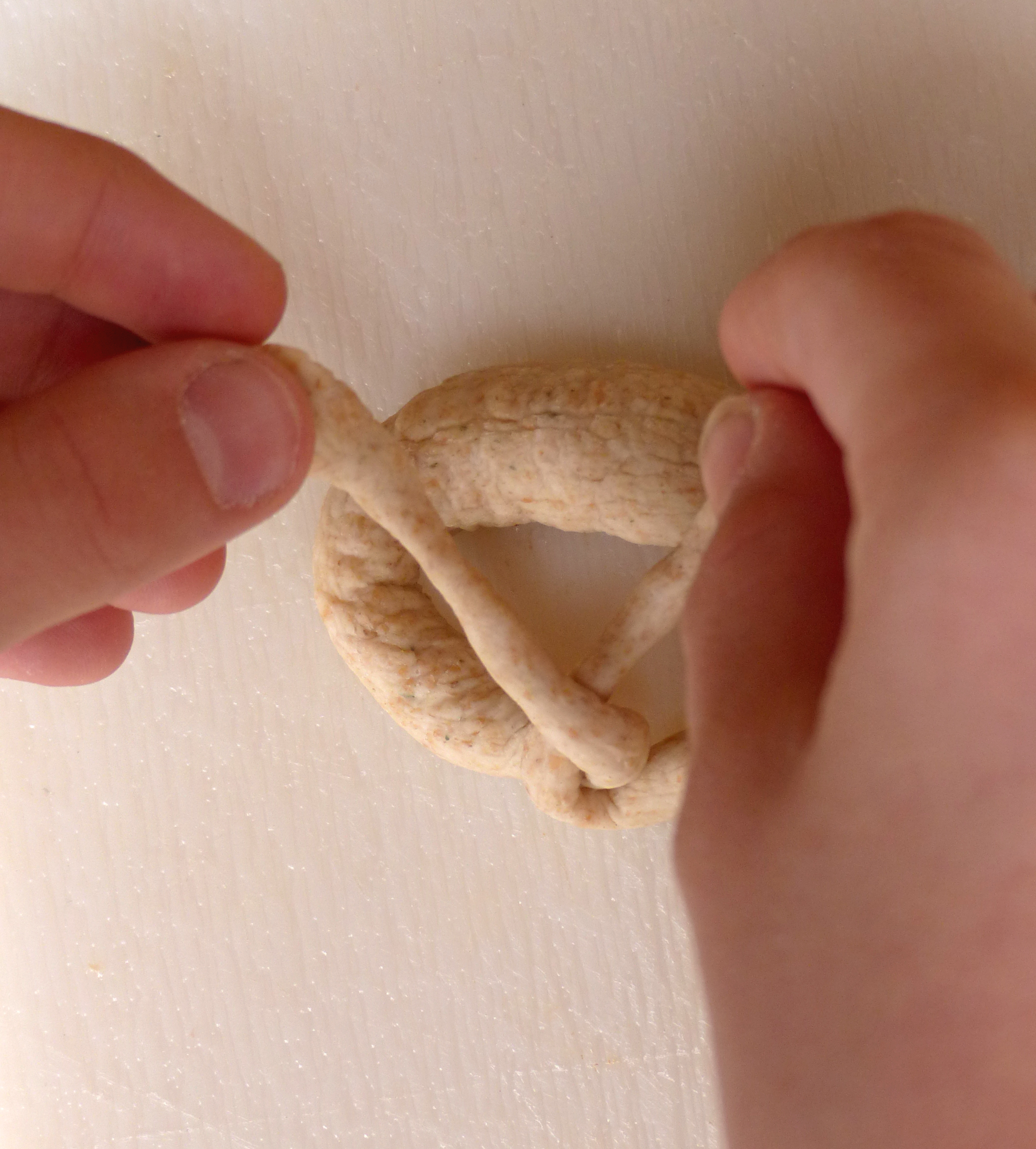 <p>Die Strangenden werden an den Brezenbogen gelegt.</p>