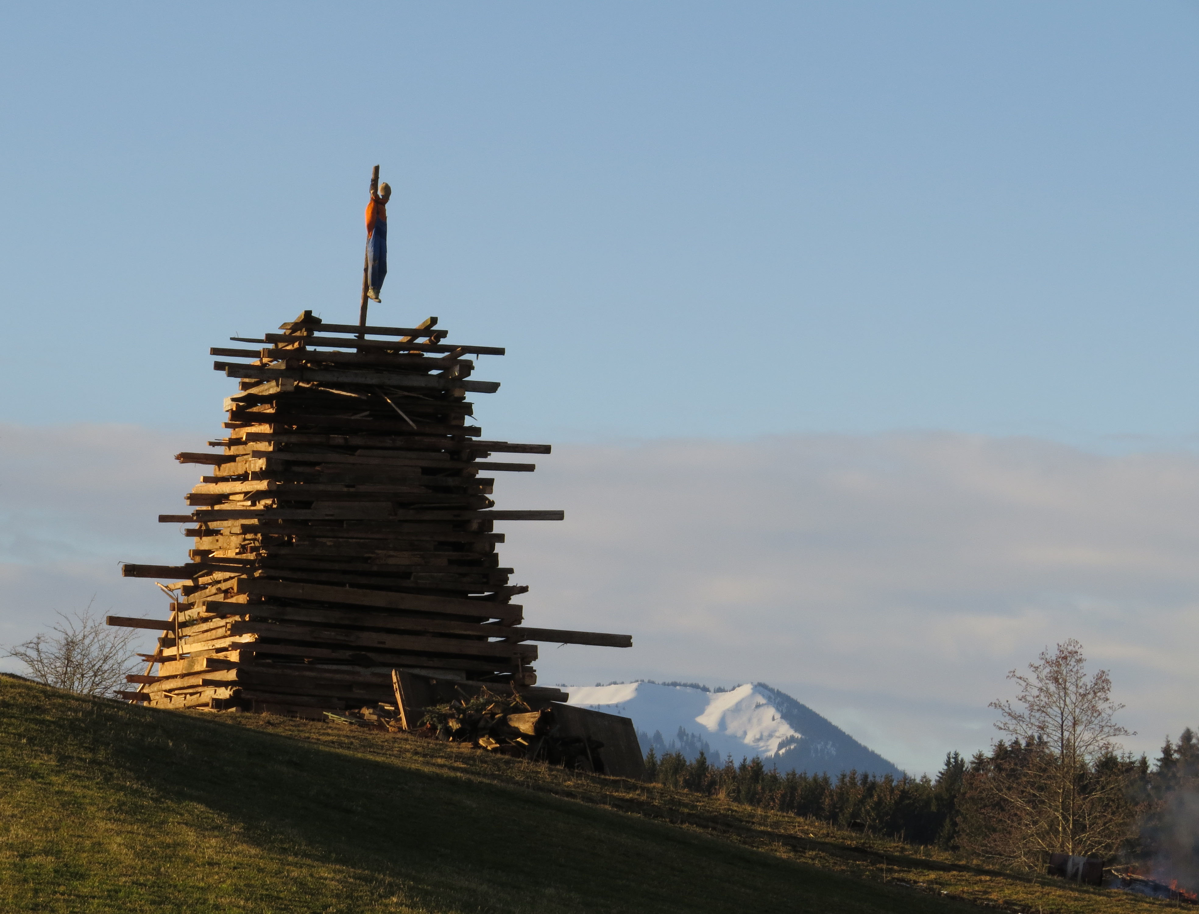 <p>Der Holzstoß („Funken“) mit der Menschen-Puppe ist aufgerichtet. Er erweckt nur mehr entsetzliche Assoziationen!</p>
<p>Quelle Bild 1: <a href="https://commons.wikimedia.org/wiki/File:G%C3%B6risried_-_Stadels_n%C3%B6rdl_-_Funken_140216_-_01.JPG">Flodur63</a></p>