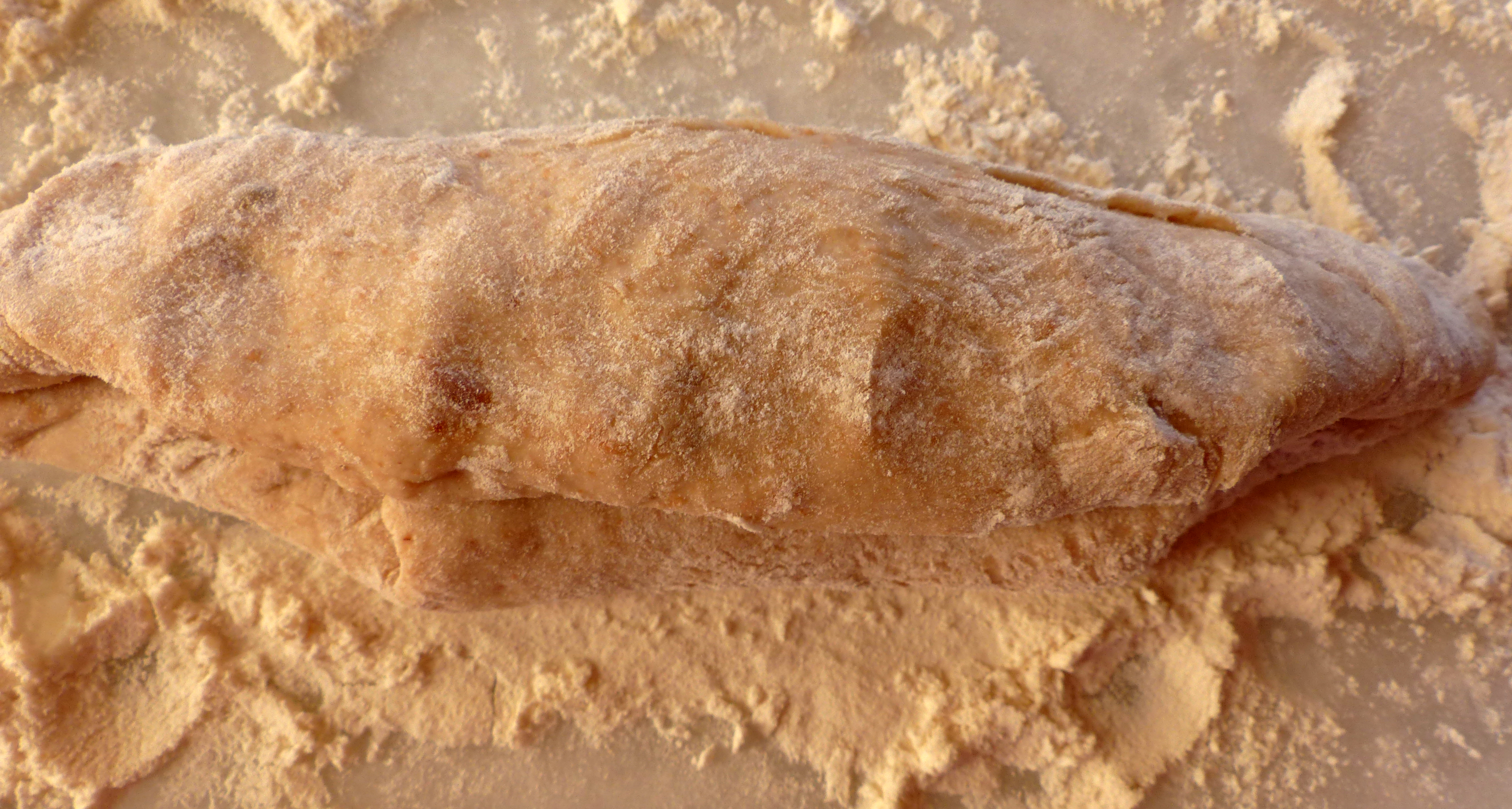 <p>Die beiden Teighälften längs aufeinandergelegen. Den Teigrand sanft andrücken - er wird als „Naht“ bezeichnet.</p>