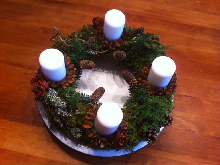 <p>Adventkranz 2013: Mit goldfarbigem Draht wurde Moos dicht an dicht auf einen Papierreifen gebunden und mit Naturmaterial besteckt, Bucheckern umrunden die Kerzen.</p>
