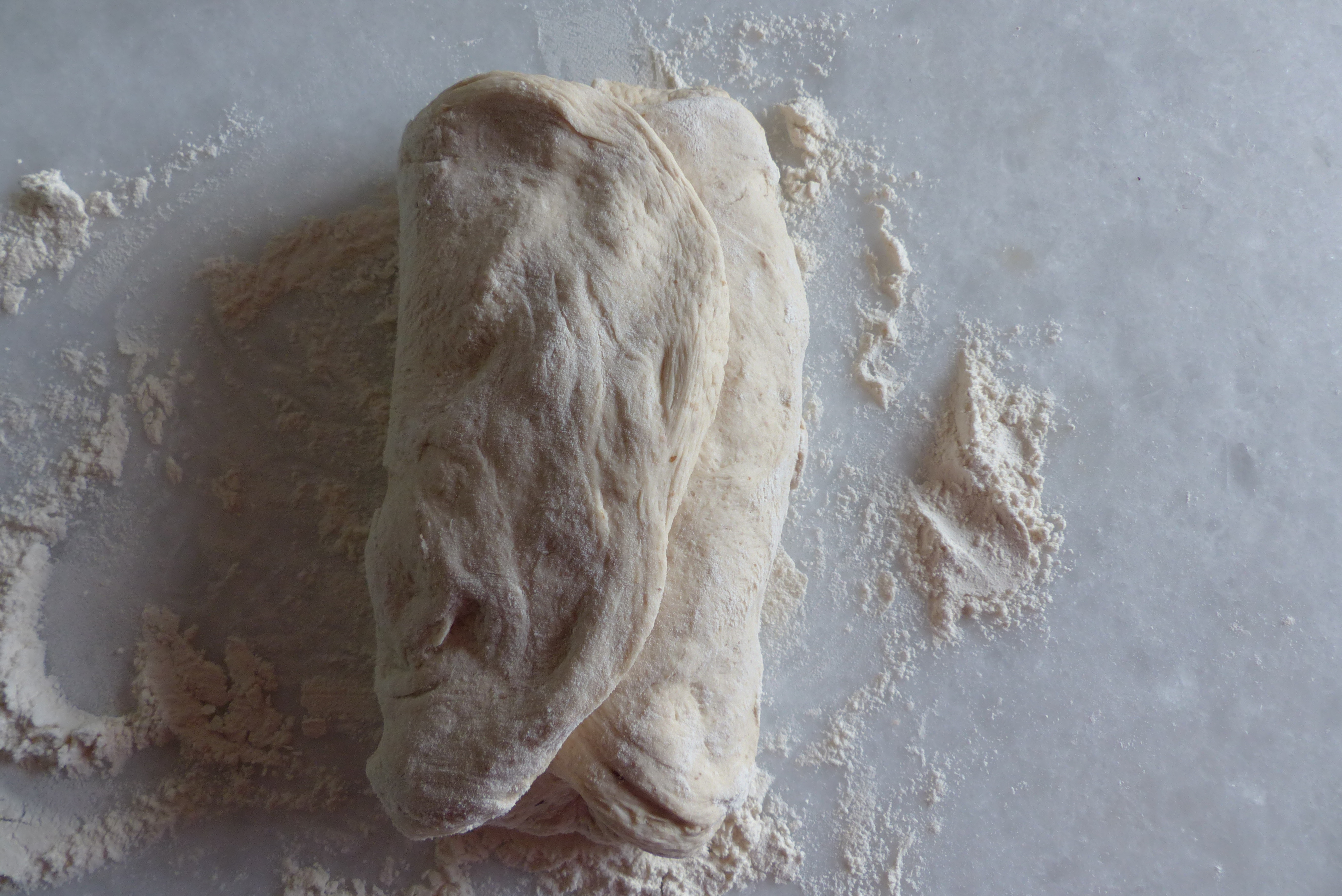 <p><em>Die beiden schmaleren</em> <em>Seiten </em>so umlegen, dass sie übereinander liegen.</p>