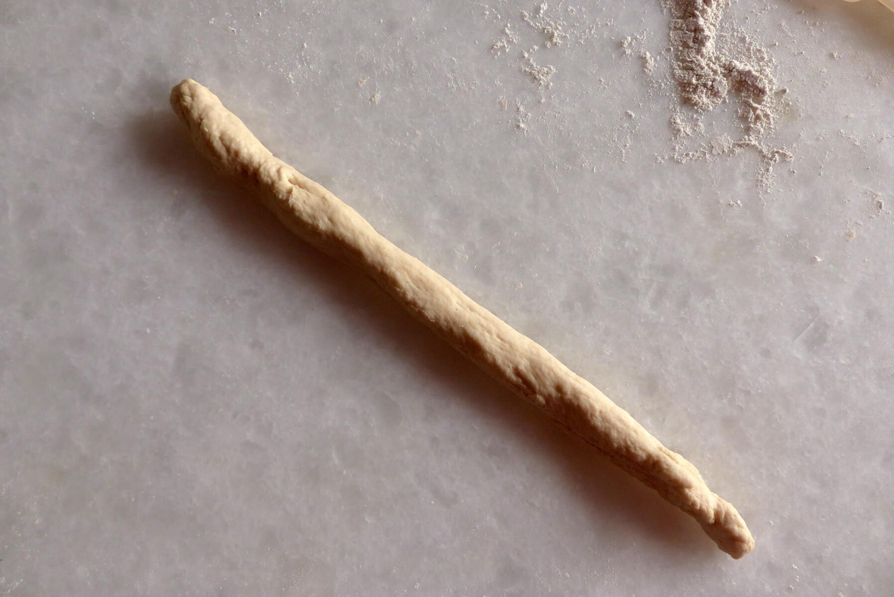 <p>Einstrangzopf - 1. Schritt:<strong> </strong></p><p>45 cm langer, dünner Teigstrang</p>