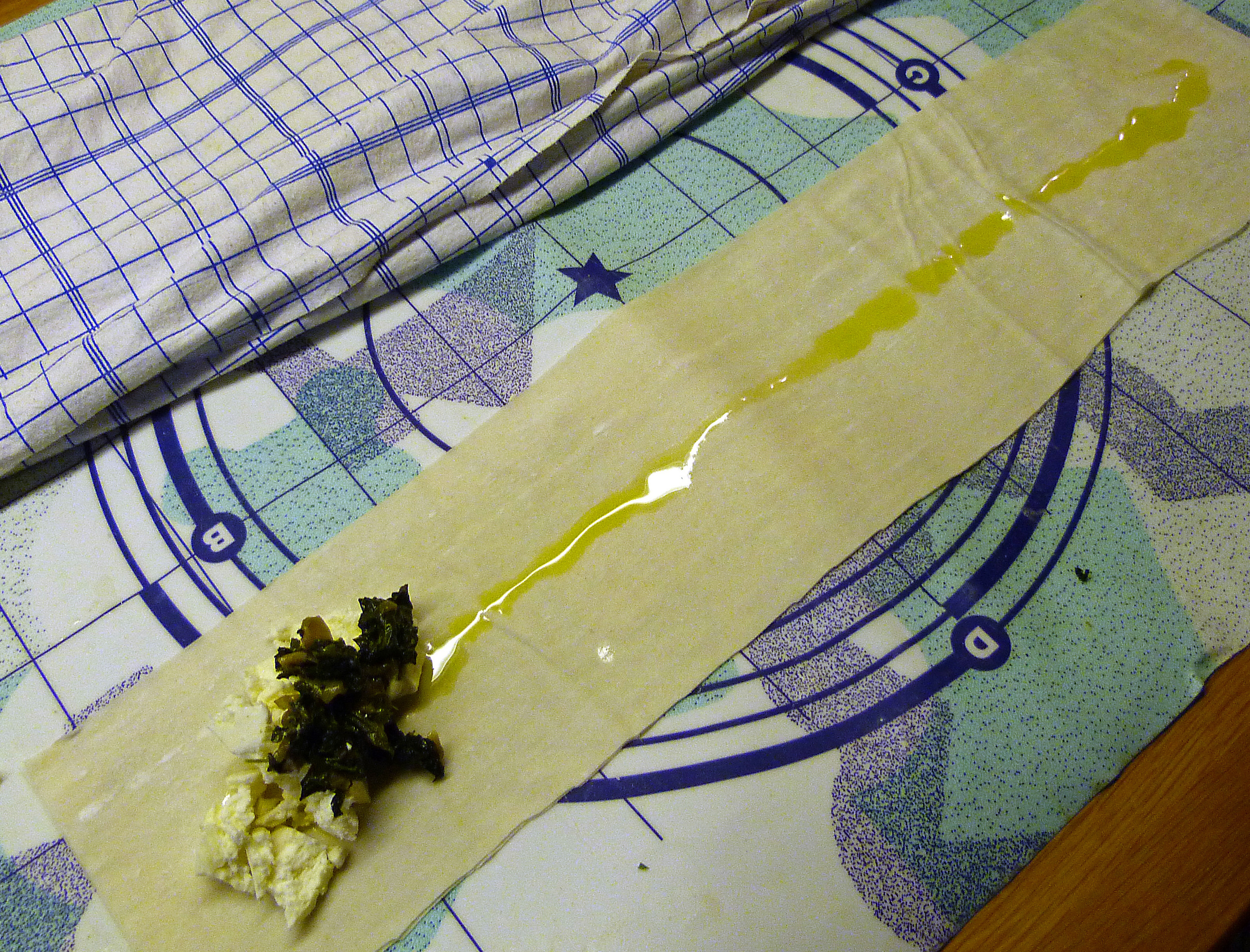 <p>Auf dem obersten Streifen eine dünne Spur Olivenöl ziehen und die Fülle darauf am linken Ende platzieren.</p>